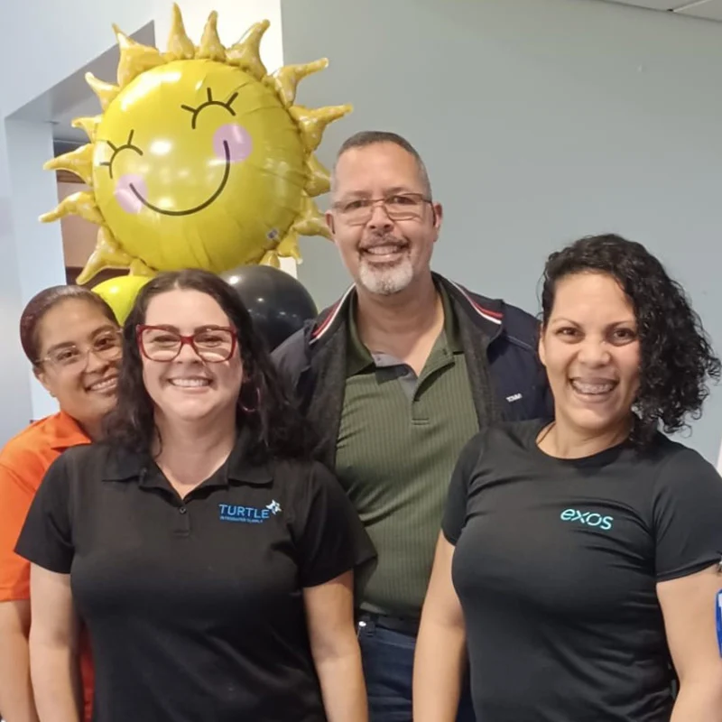 Close-up of four Turtle Company team members with sun balloon