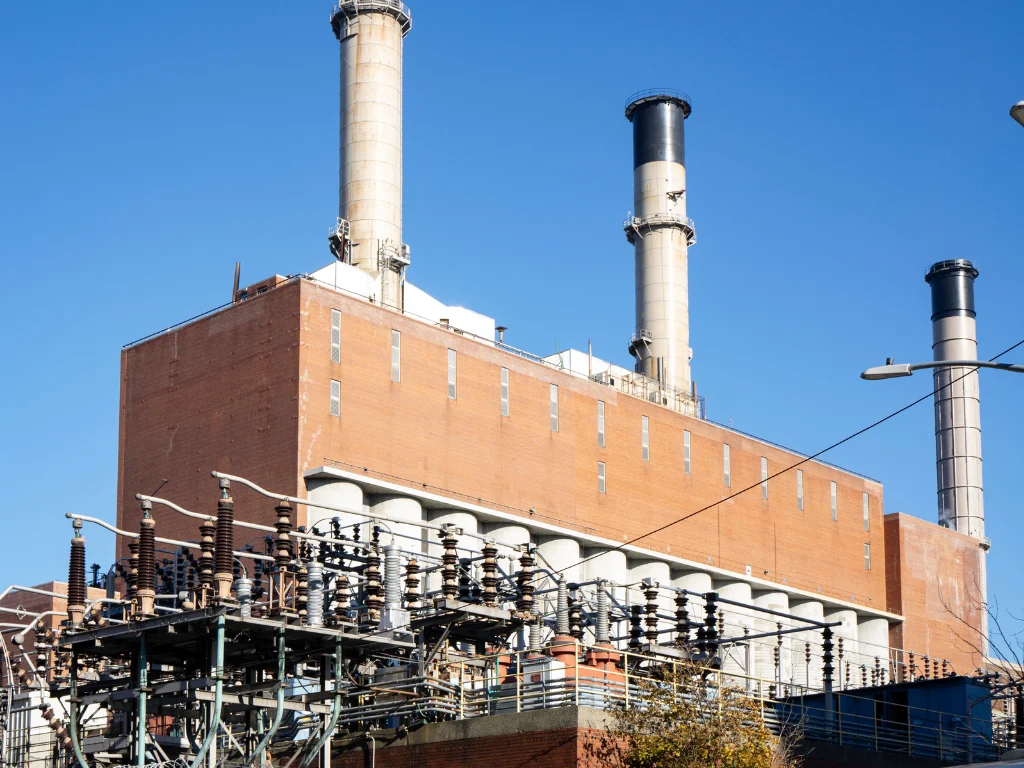 Brick power plant with smokestacks and electrical substation