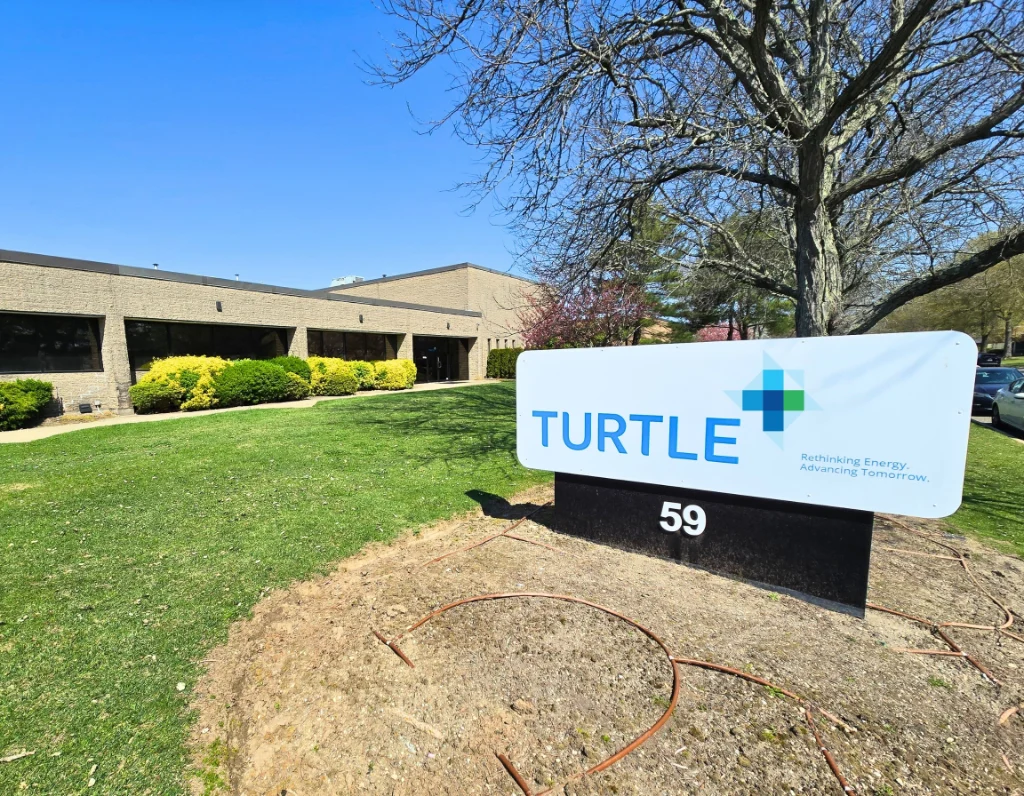 Turtle Company location sign on lawn outside building