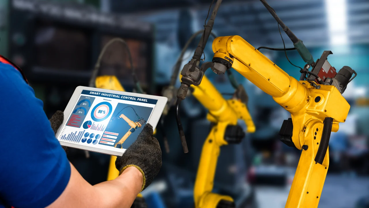 Two gloved hands holding a tablet controller for industrial automation machinery