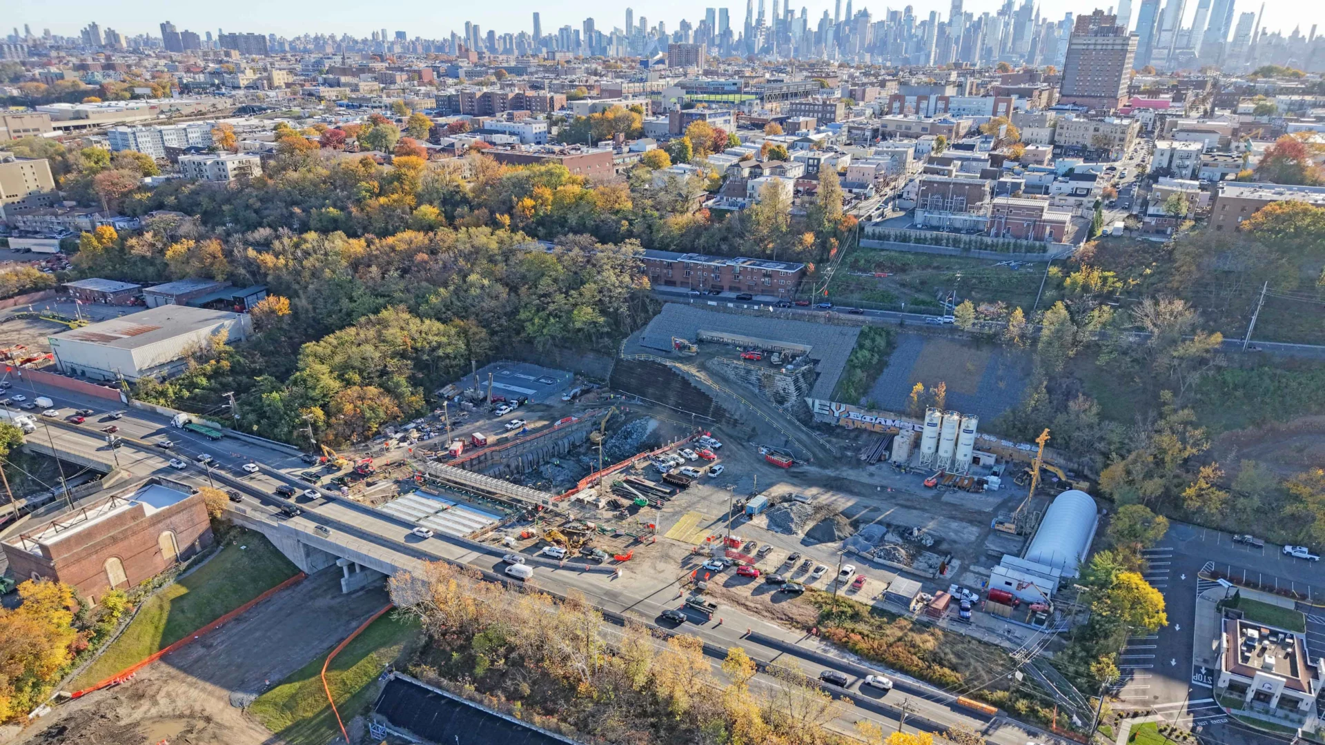 Aerial view of Palisades Tunnel construction with New York City skyline in the background.